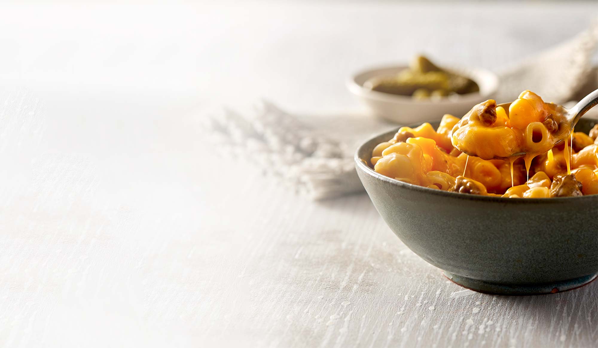 A gray ceramic bowl filled with creamy macaroni and cheese.