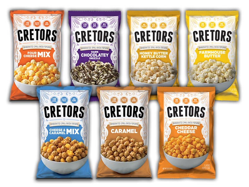 Two rows, four in back three in front, of seven bags of Cretors popcorn products ranging from Four Cheese to Caramel options. 