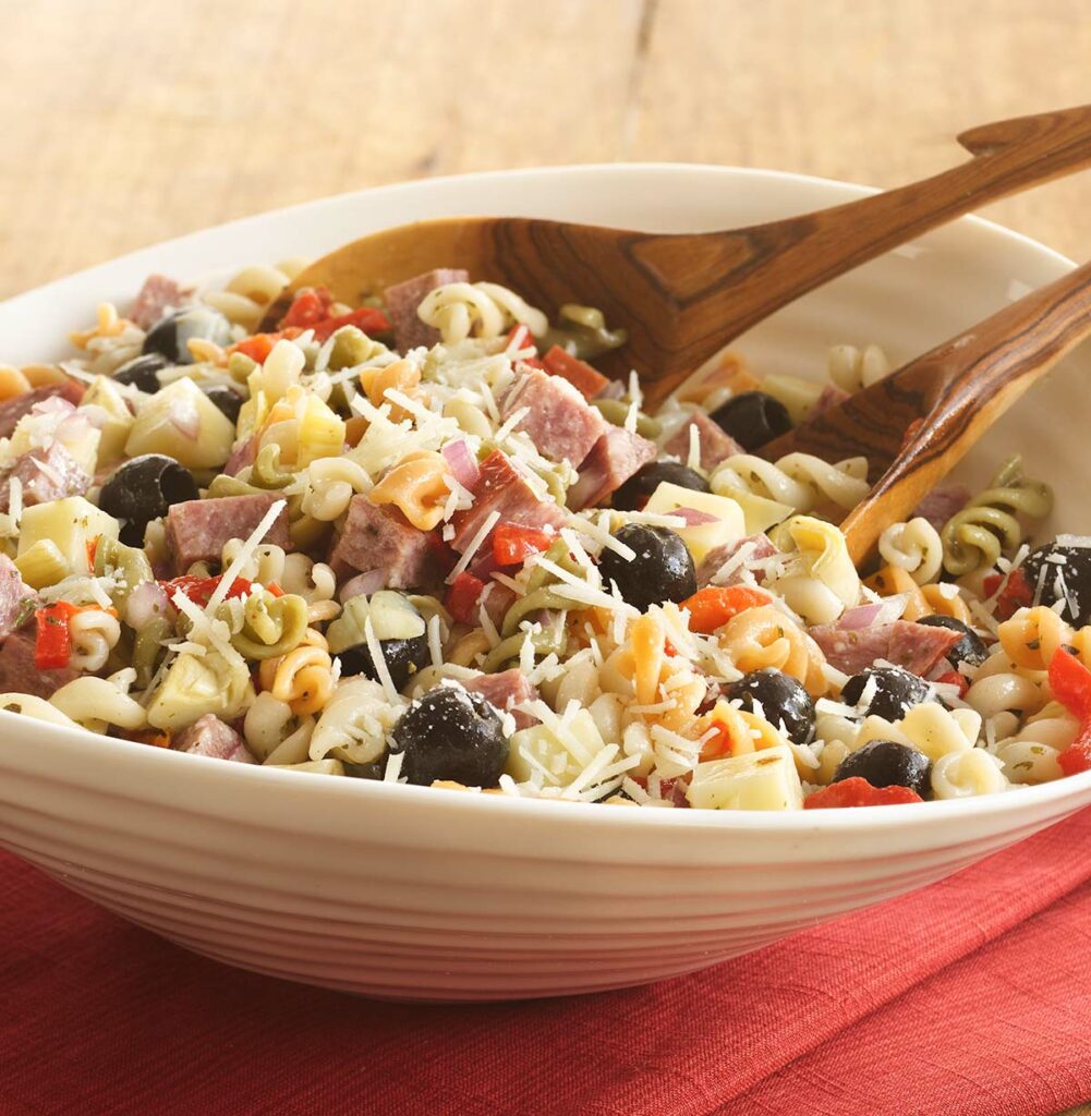 Large white bowl of Suddenly Pasta Salad with black olives and cheese. 