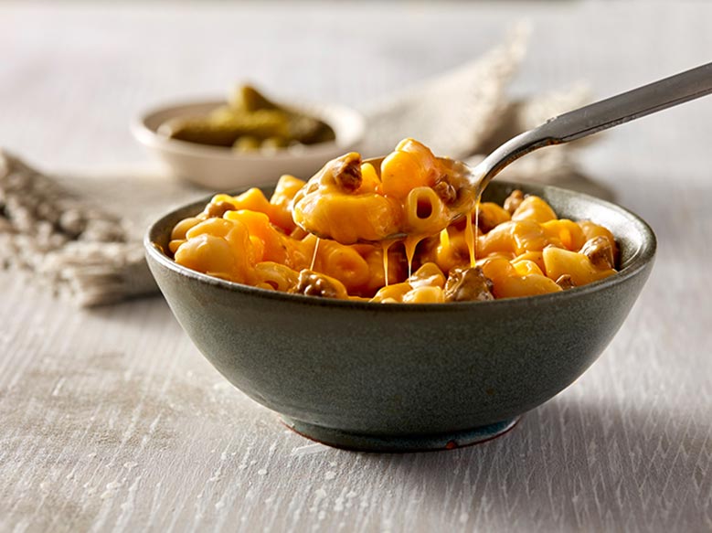 A gray ceramic bowl filled with creamy macaroni and cheese.